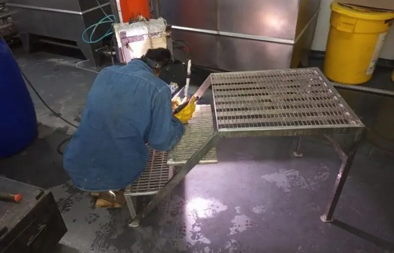 Grupo Tecnolog welder fabricating a custom metal walkway in the workshop